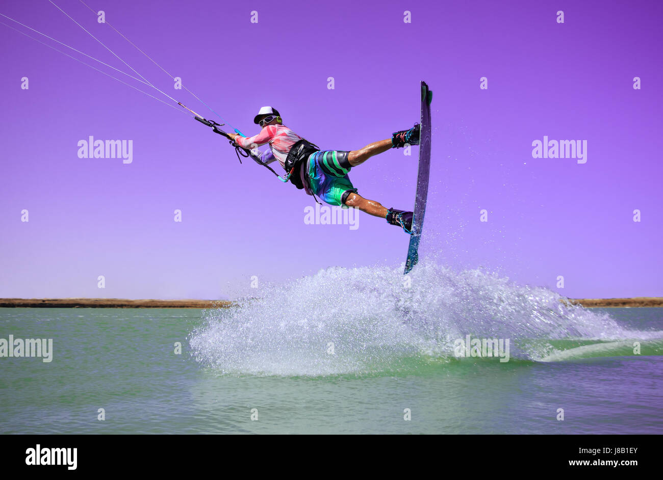 Professionellen Kite boarding Fahrer Sportler springt hoch Akrobatik Kiteboarding raley Trick mit riesigen Spritzwasser. Freizeitbeschäftigung und extreme Stockfoto