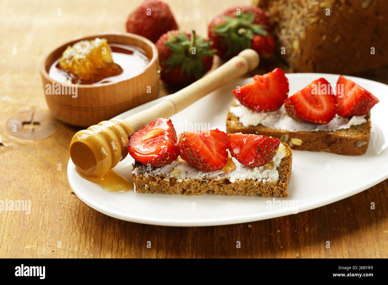 Sandwich mit Frischkäse, Erdbeeren und Honig Stockfoto