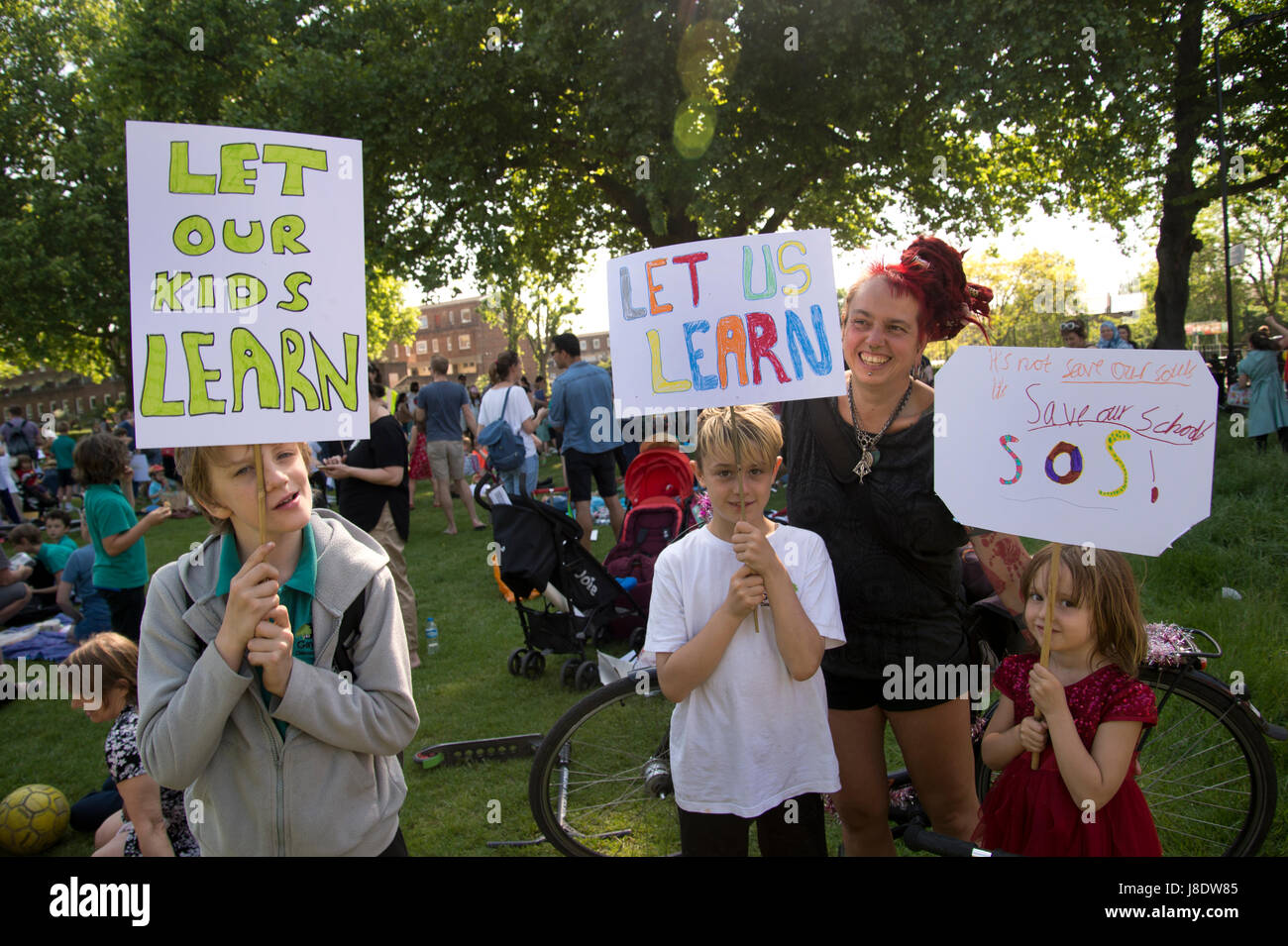 London Fields, Hackney. Protest gegen die Regierung plant, mehr als 600 Lehrer in Hackney zu schneiden. Drei Kinder halten Schilder mit der Aufschrift, "unsere Kinder lernen lassen", Stockfoto