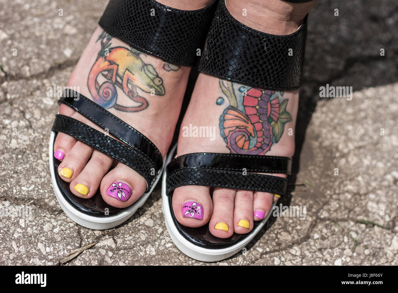 weibliche Füße in Sandalen mit Tattoo closeup Stockfoto