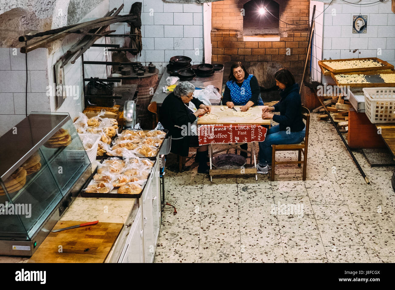 Drei Generationen von Frauen bereiten traditionelle Orecchiette Nudeln in Bari Vecchia, Apulien, Italien Stockfoto