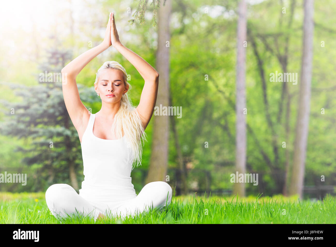 Junges Mädchen Lotus Yoga trainieren im Frühlingspark Stockfoto