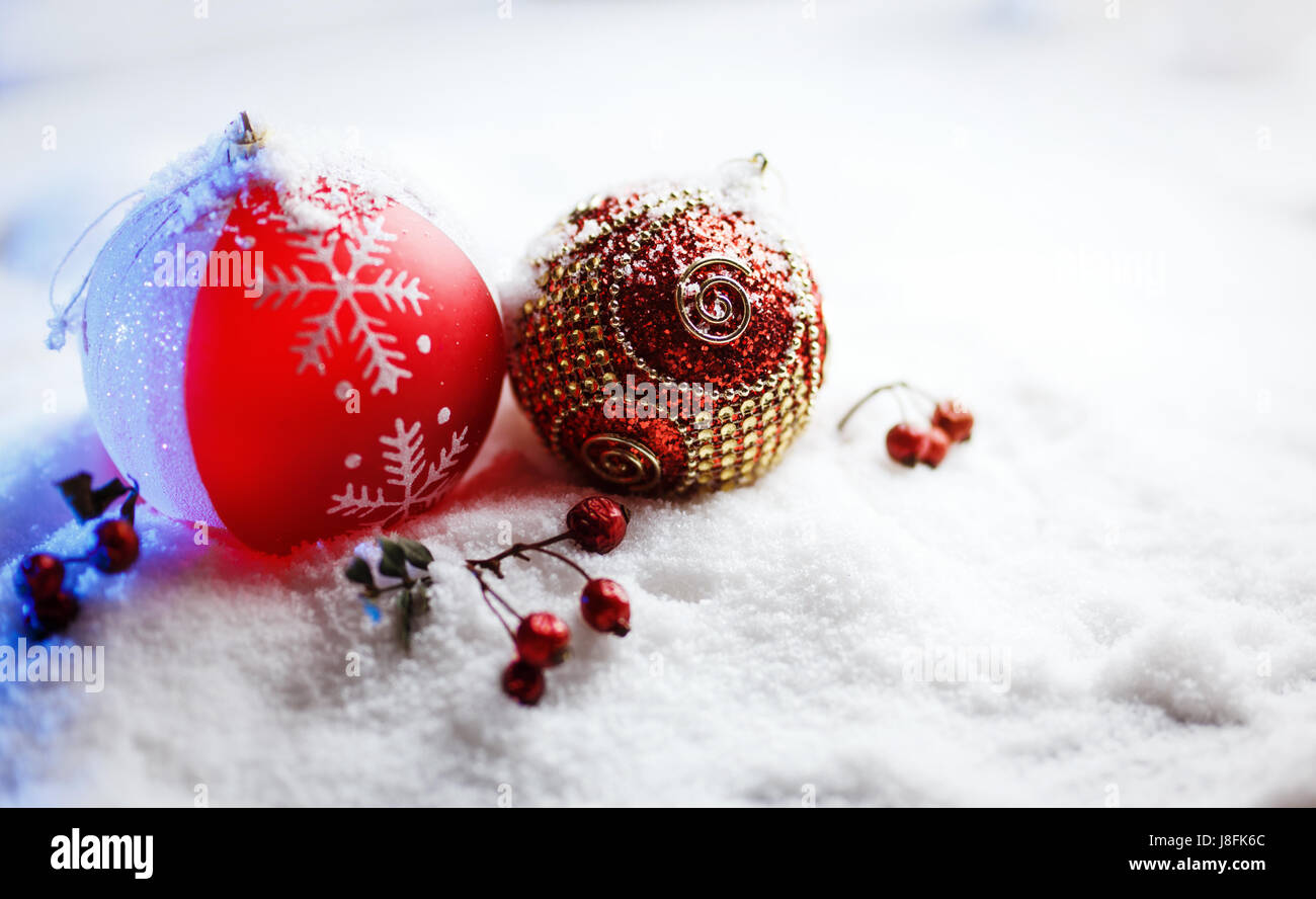 Verzierten Weihnachtskugeln im Schnee mit blauer Hintergrundbeleuchtung. Stockfoto