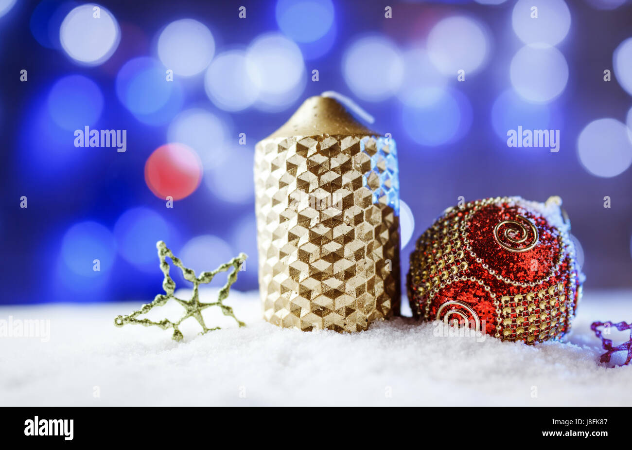 Kerze und Weihnachten Dekoration im Schnee mit blauem Licht Hintergrund. Stockfoto