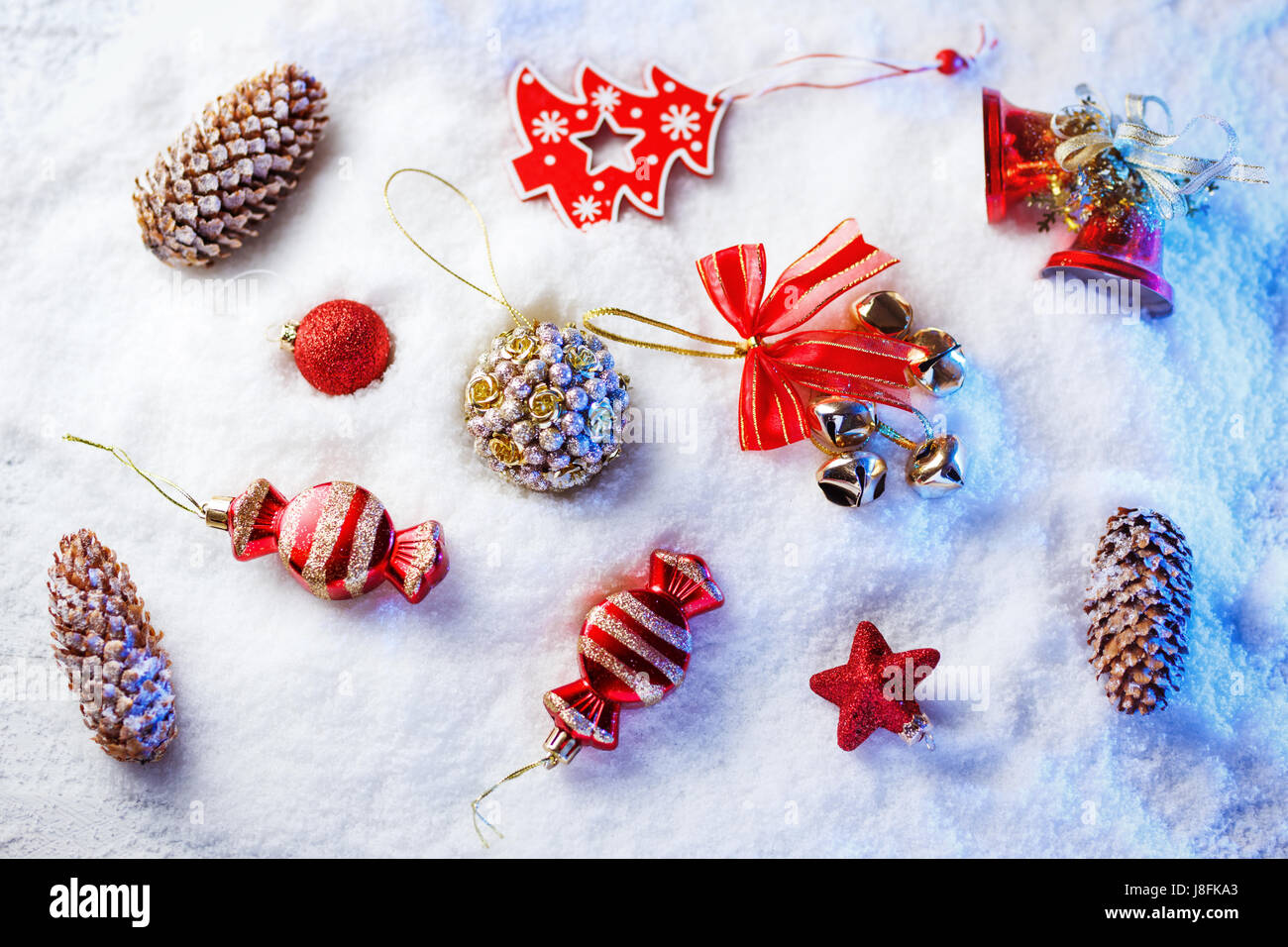 Weihnachtsschmuck im Schnee mit blauer Hintergrundbeleuchtung. Stockfoto