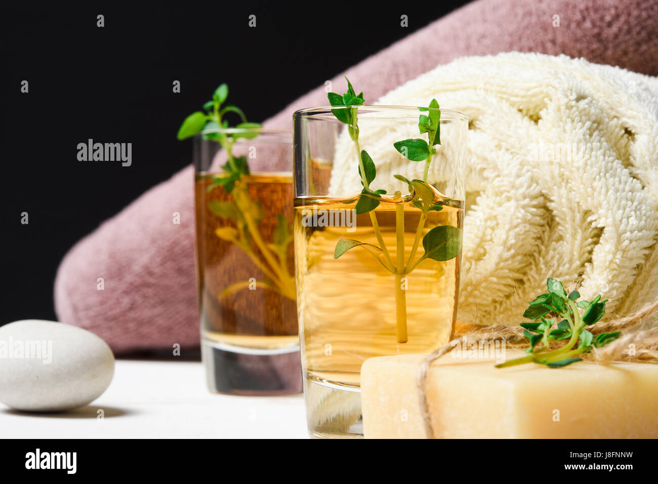 Massage oder Aromatherapie Set: Thymian, Öl, Steinen und Seife Nahaufnahme Stockfoto