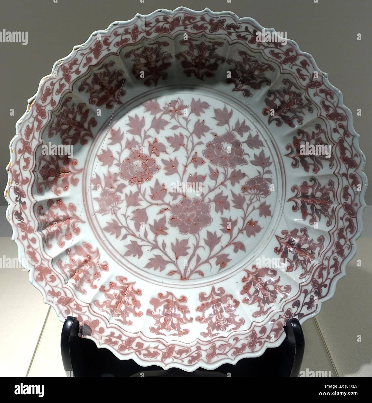 Dieses große Gericht, das während der Hongwu-Zeit der Ming-Dynastie im Jingdezhen-Ofen hergestellt wurde, weist ein Pfingstrosendesign auf, ein gängiges Motiv aus chinesischem Porzellan. Die unterglasierte kupferrote Dekoration steht für hochwertige Handwerkskunst der Epoche und ist im Matsuoka Museum of Art in Tokio untergebracht. Stockfoto