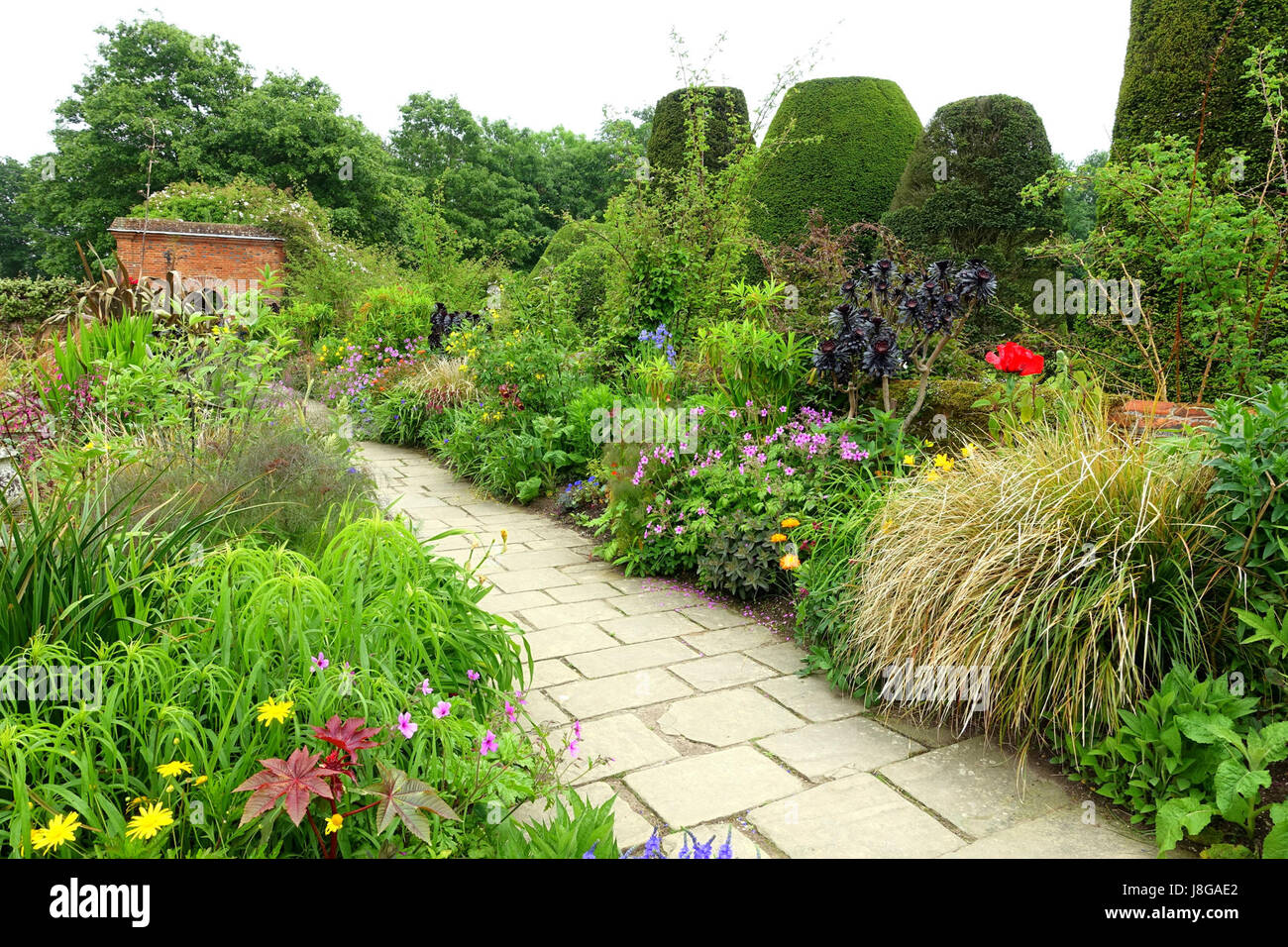 Der Gartenspaziergang im Packwood House in Warwickshire, England, bietet einen malerischen Blick auf das Gelände der estateâ. Der Garten spiegelt traditionelle englische Landschaftsgestaltung und das Erbe der Familie Packwood wider. Stockfoto
