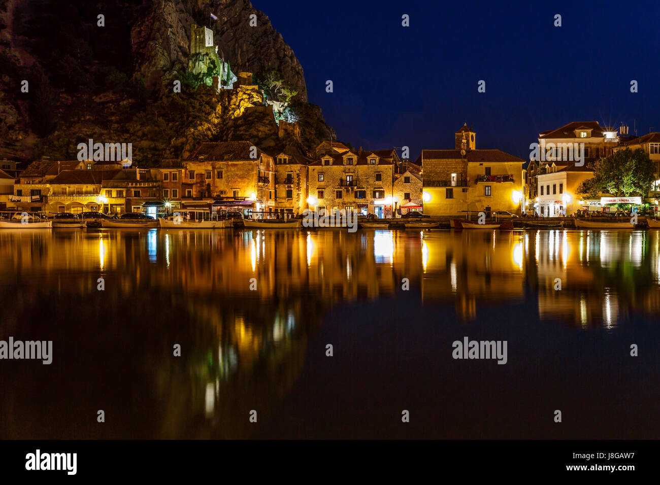 Beleuchtete Piraten-Burg und Stadt Omis, reflektiert in der Fluss Cetina in der Nacht, Kroatien Stockfoto