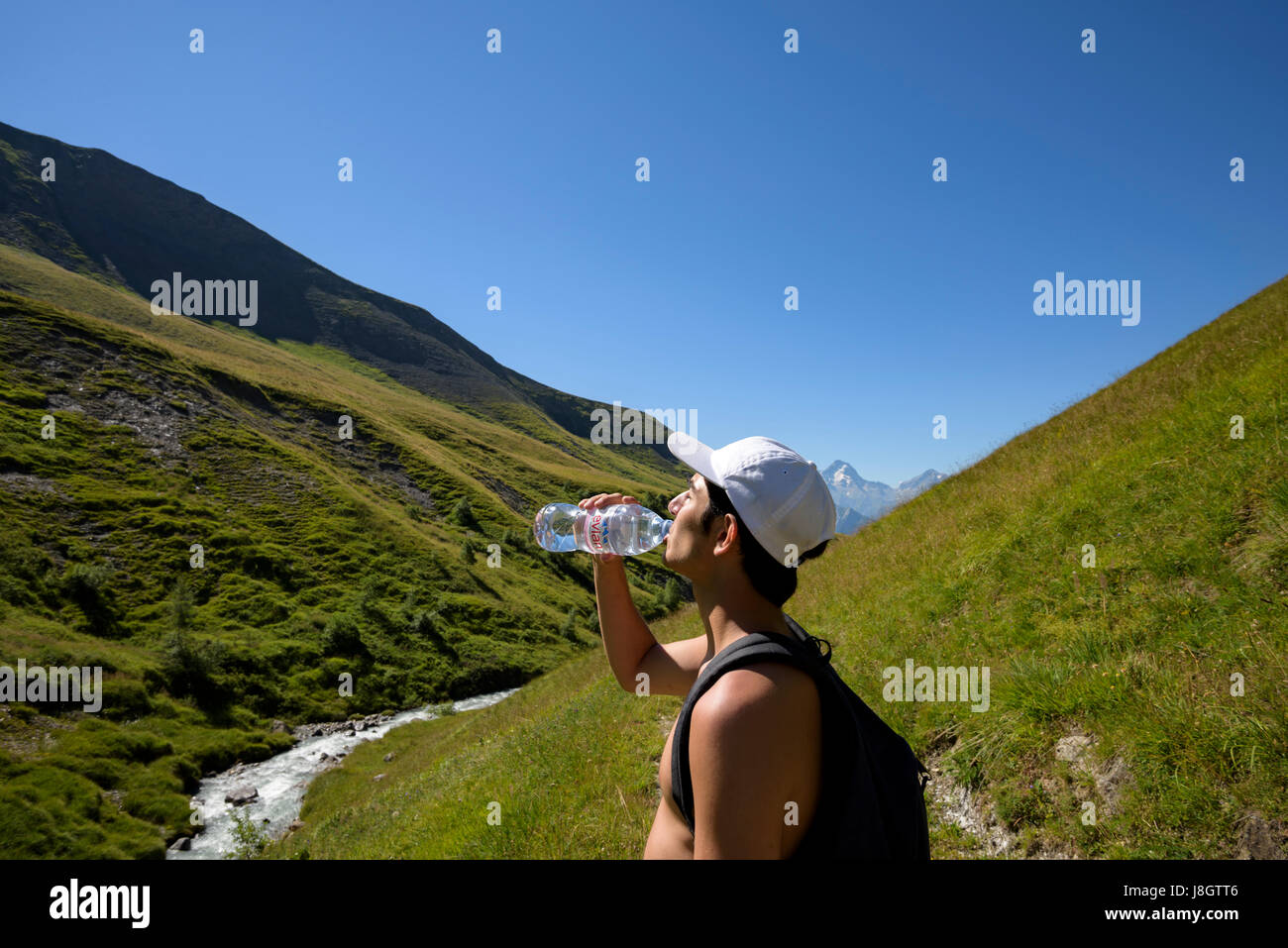 Teenager, Junge, trinkt Evian-Wasser während einer Wanderung in den Bergen, französische Alpen, Frankreich Stockfoto