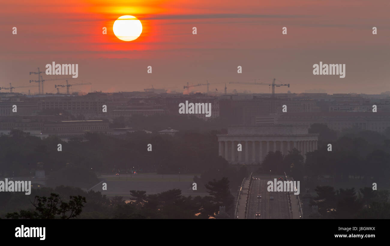 Die Sonne steigt über den Gedenkstätten und Baukräne in Washington, D.C. Stockfoto