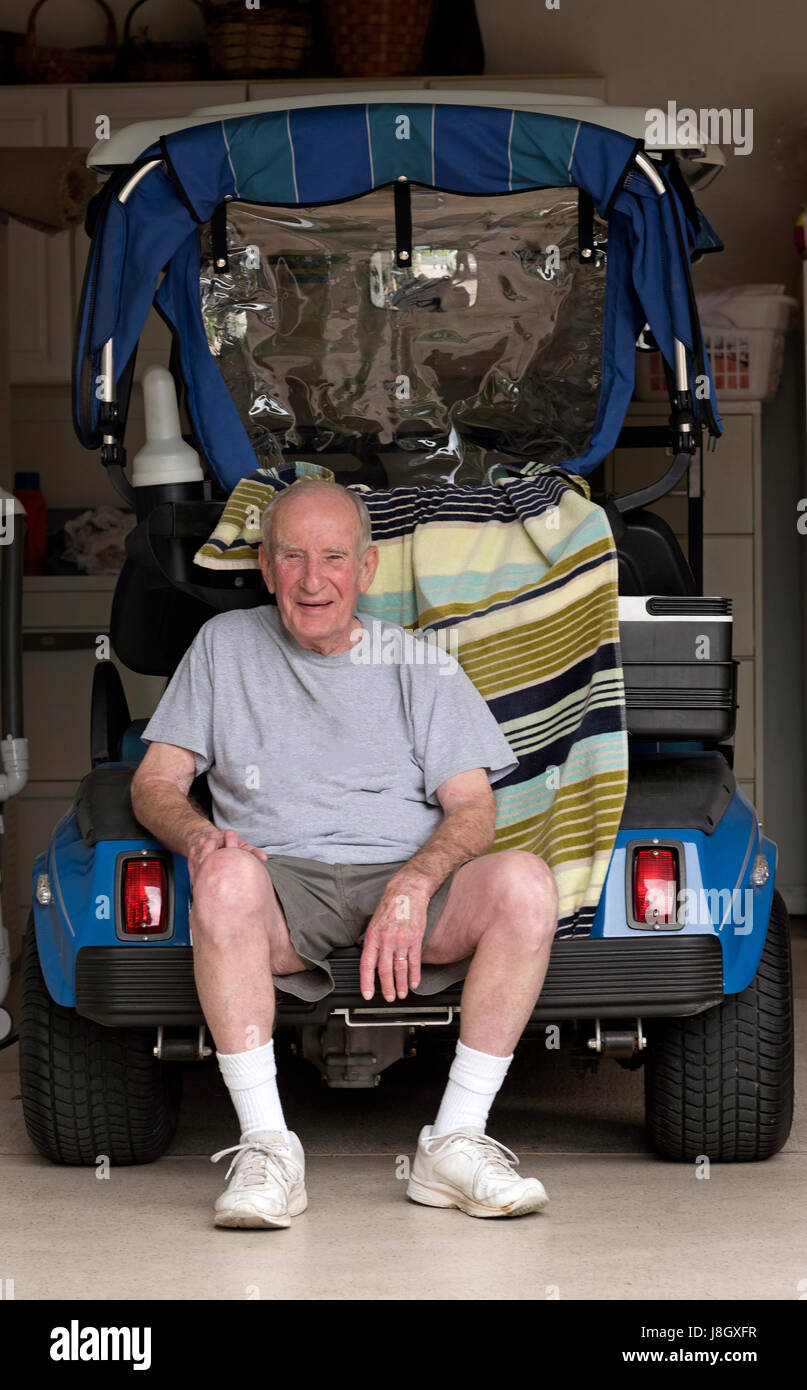 Entspannen Sie sich auf der Rückseite der seinen Golf-Cart älterer Mann Stockfoto