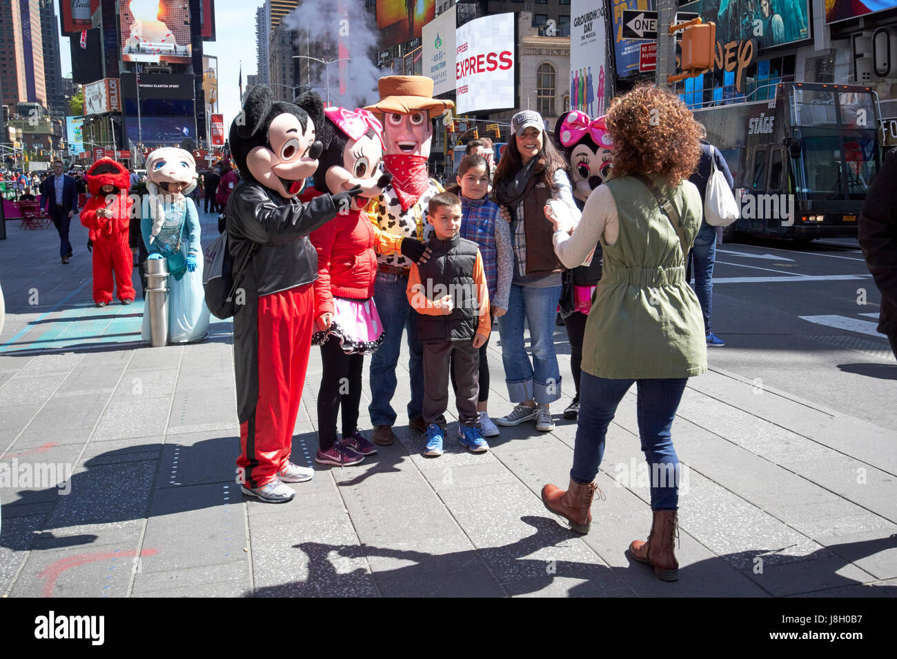 Kinder und Touristen posieren für Fotos mit Menschen angezogen als animierte Charaktere in Times Square New York City USA Stockfoto