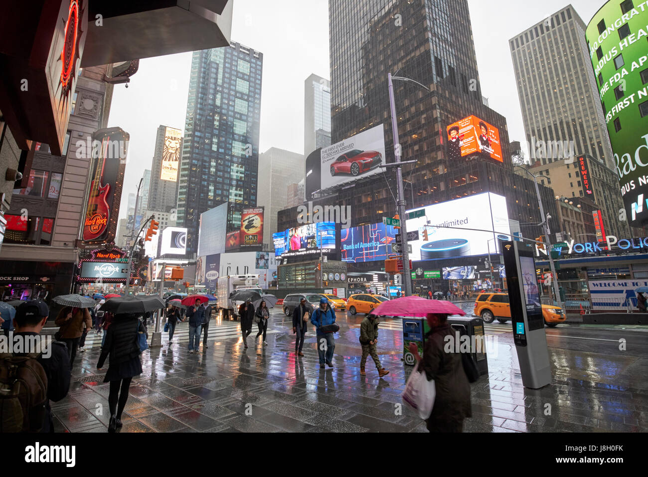 Menschen halten Sonnenschirme Fuß über den nassen Times Square während Regen Dusche Midtown New York City USA Stockfoto