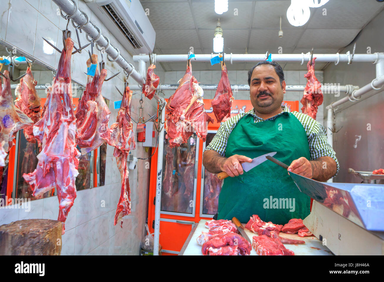Bandar Abbas, Provinz Hormozgan, Iran - 16. April 2017: iranische Metzger schneidet Portionen Fleisch auf dem Basar. Stockfoto