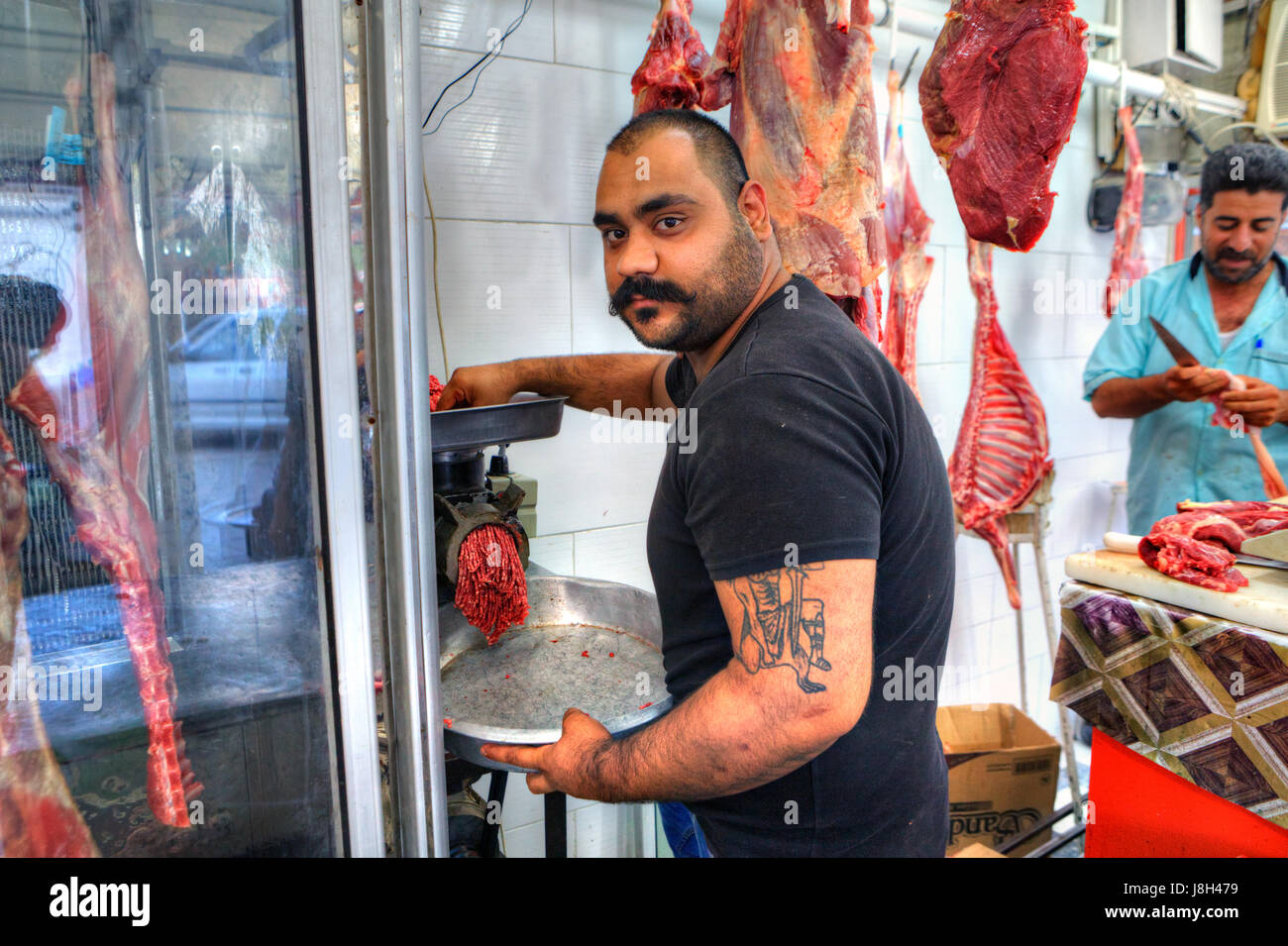 Bandar Abbas, Provinz Hormozgan, Iran - 16. April 2017: der Metzger geht Fleisch durch den Fleischwolf, Herstellung von Hackfleisch / Faschiertem in einer Metzgerei. Stockfoto