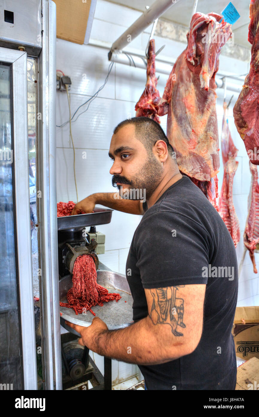 Bandar Abbas, Provinz Hormozgan, Iran - 16. April 2017: der Metzger produziert Hackfleisch mit einem Fleischwolf in einer Metzgerei. Stockfoto