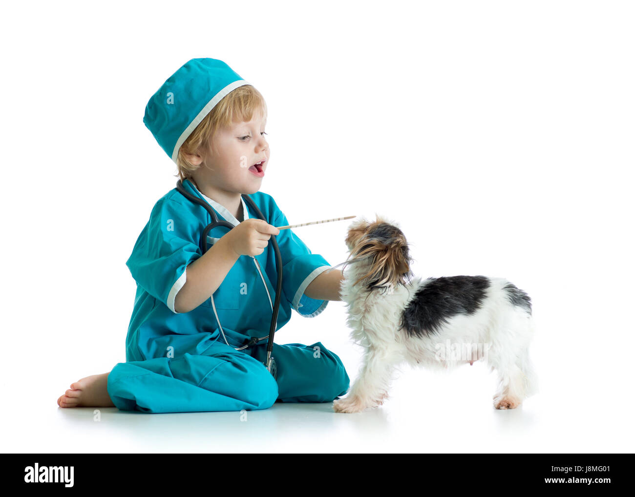 Kind weared Arzt Kleidung spielen Tierarzt mit Hund Stockfoto