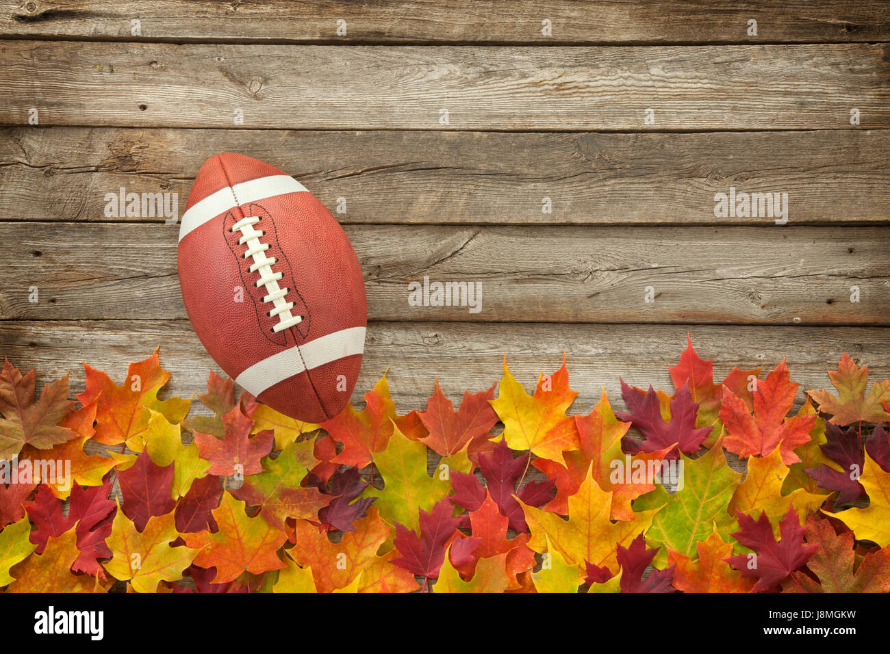 Hochschulfußball Stil auf Blätter fallen und grobe Holz Draufsicht Stockfoto