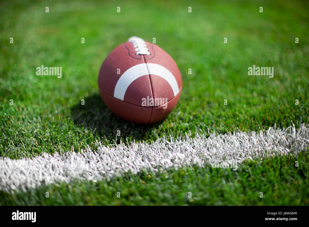 College-Football sitzt an einem Yard-Linie oder Ziel der Wiese mit defokussierten Hintergrund Stockfoto