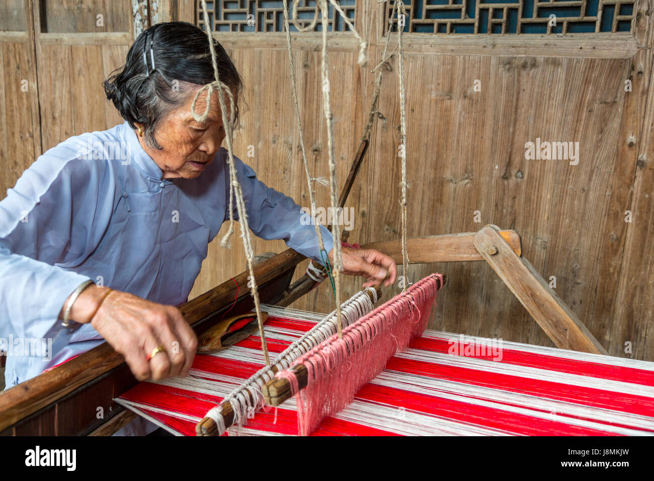 Yubei, Zhejiang, China.  Senior Frau an ihrem Webstuhl weben. Stockfoto