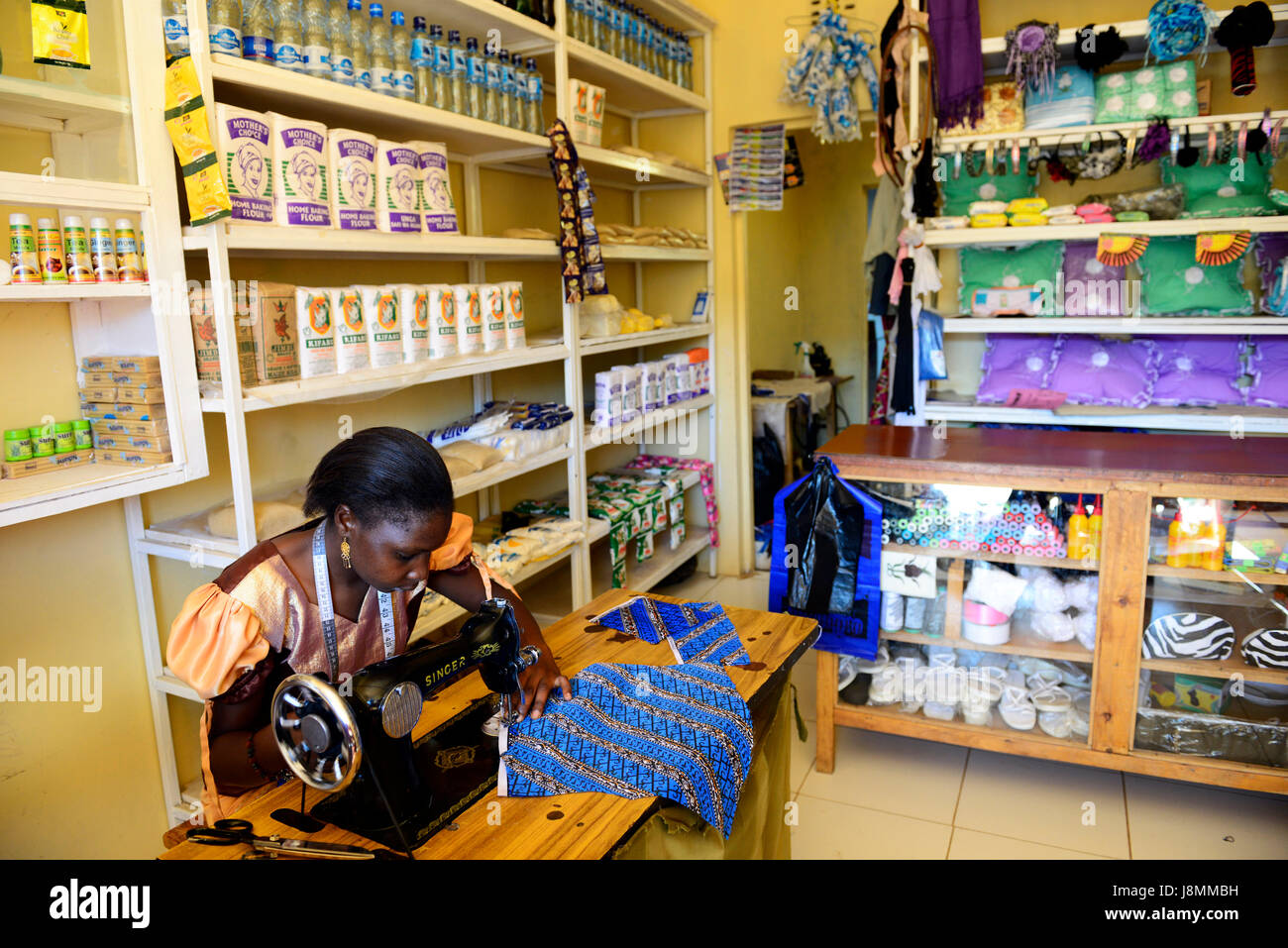 Eine kenianische Frau nähen ein Kleid mit ihrem Sänger Maschine mit Hilfe eines Micorofinance Darlehen für kleine Unternehmen erworben. Stockfoto