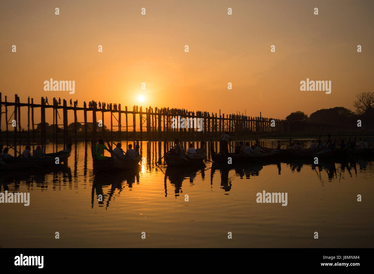 Silhouetten von Touristen in Boote bewundern U Bein Brücke über den Taungthaman-See bei Sonnenuntergang, in Amarapura, Mandalay, Myanmar Stockfoto