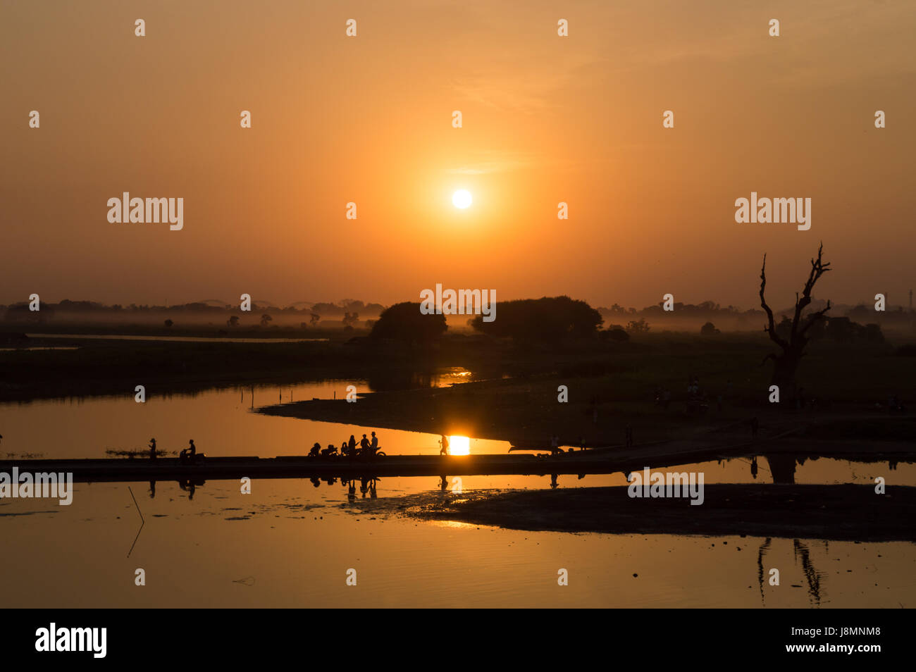 Silhouetten von Menschen auf Taungthaman See bei Sonnenuntergang, in Amarapura, Mandalay, Myanmar Stockfoto
