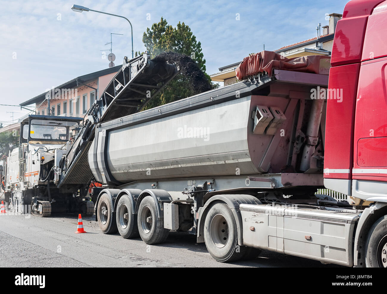 Straßenbau, asphalt-Einbau einer Straße. Muldenkipper ist mit Asphalt gefräst aus kalten Hobel Maschine geladen. Stockfoto