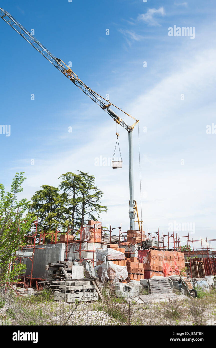 Kleine Baustelle mit Häuser im Bau. Baukräne, Gerüste, Ziegeln und anderen Baustoffen. Stockfoto