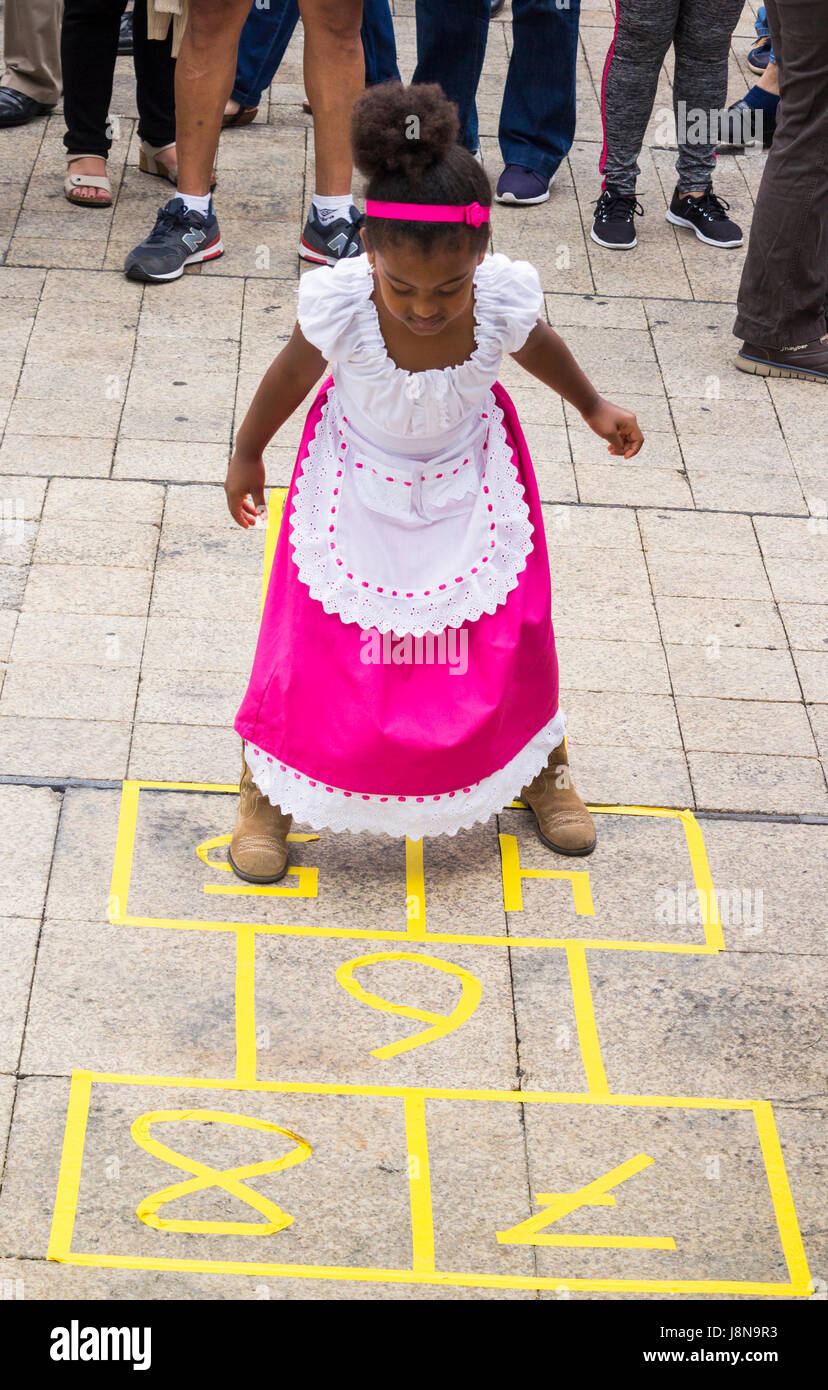 Ein junges Mädchen in Tracht spielen Hopse auf lokaler Fiesta auf Gran Canaria, Kanarische Inseln, Spanien. Stockfoto