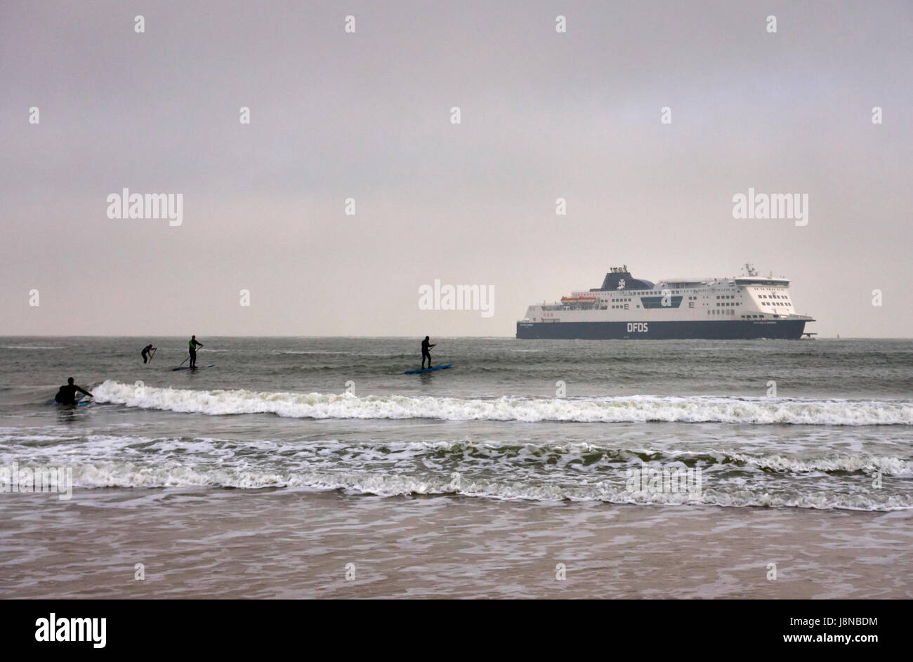 Calais Normandie Frankreich, Surfer Rudern auf dem offenen Meer, wenn die Fähre anreisen, wird von Großbritannien nähert sich der Hafen in Wetter Stockfoto