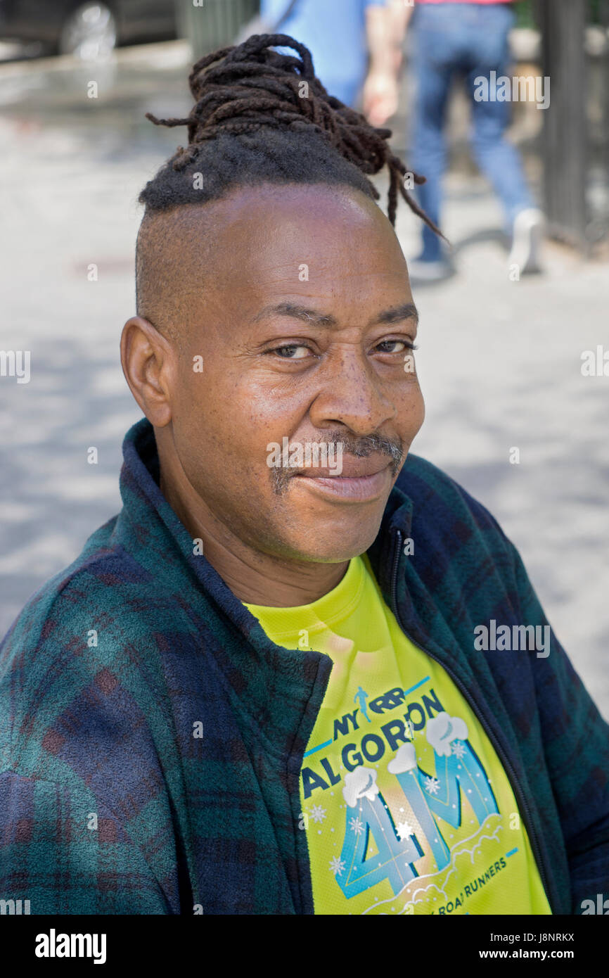 Porträt eines Mannes in Union Square Park mit einem einzigartigen Frisur, die teilweise dreadlocks und teilweise rasiert. Manhattan, New York City. Stockfoto