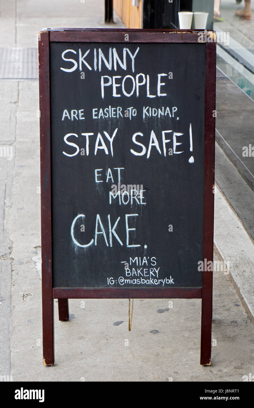 Ein sehr lustigen Zeichen außerhalb von Mias Bäckerei auf Smith Street in Coblle Hill die Menschen ermutigen, mehr Kuchen essen. Brooklyn, New York City Stockfoto