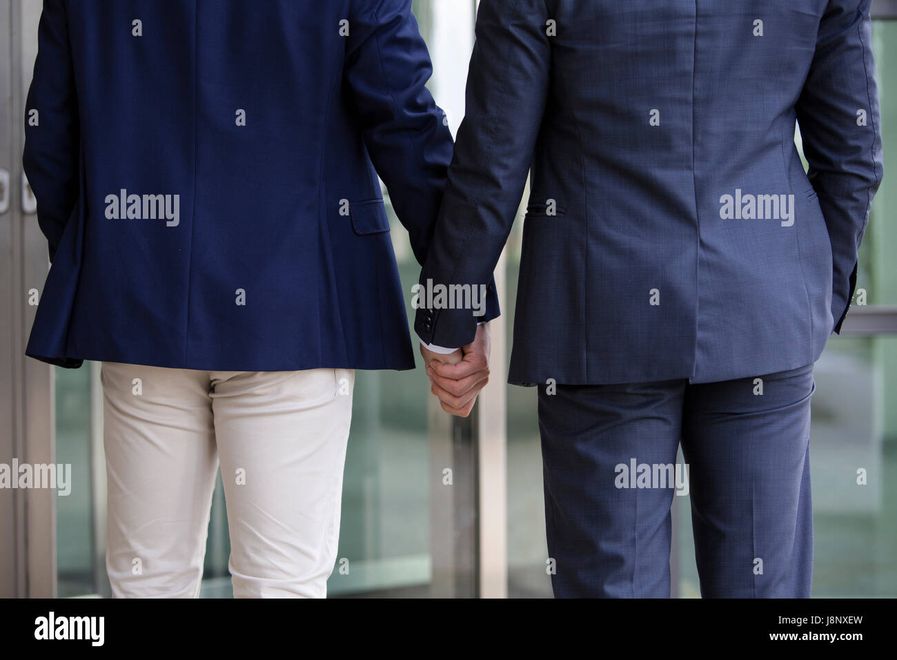 zwei Männer in Anzüge stehen und halten die Hände Stockfoto