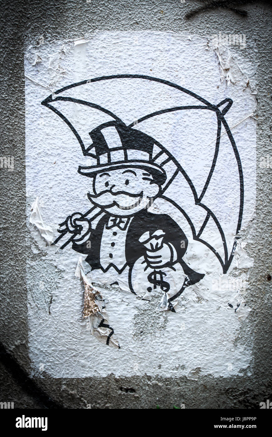 Mr. Monopoly der Kapitalist in Hong Kong. Zusammen mit einer Tasche von Bargeld hält er einen Regenschirm der Regenschirm Revolution Studentenproteste des symbolischen Stockfoto