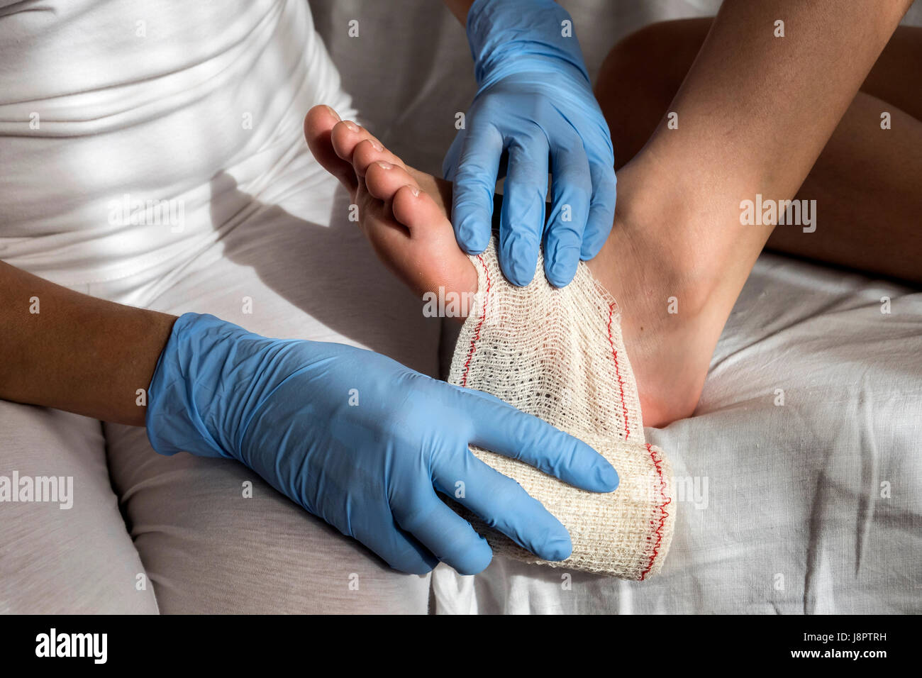 Nahaufnahme einer Krankenschwester Bandage auf Patientenfußes binden Stockfoto