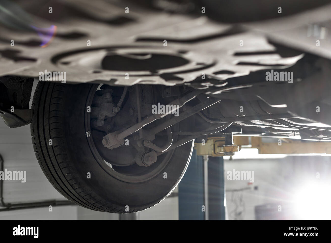 hinten Sie Auto-Federung. die Garage Mechaniker das Auto auf der Hebebühne angehoben Stockfoto