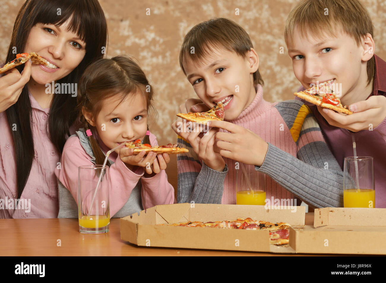 Mutter mit Kindern Pizza essen Stockfoto