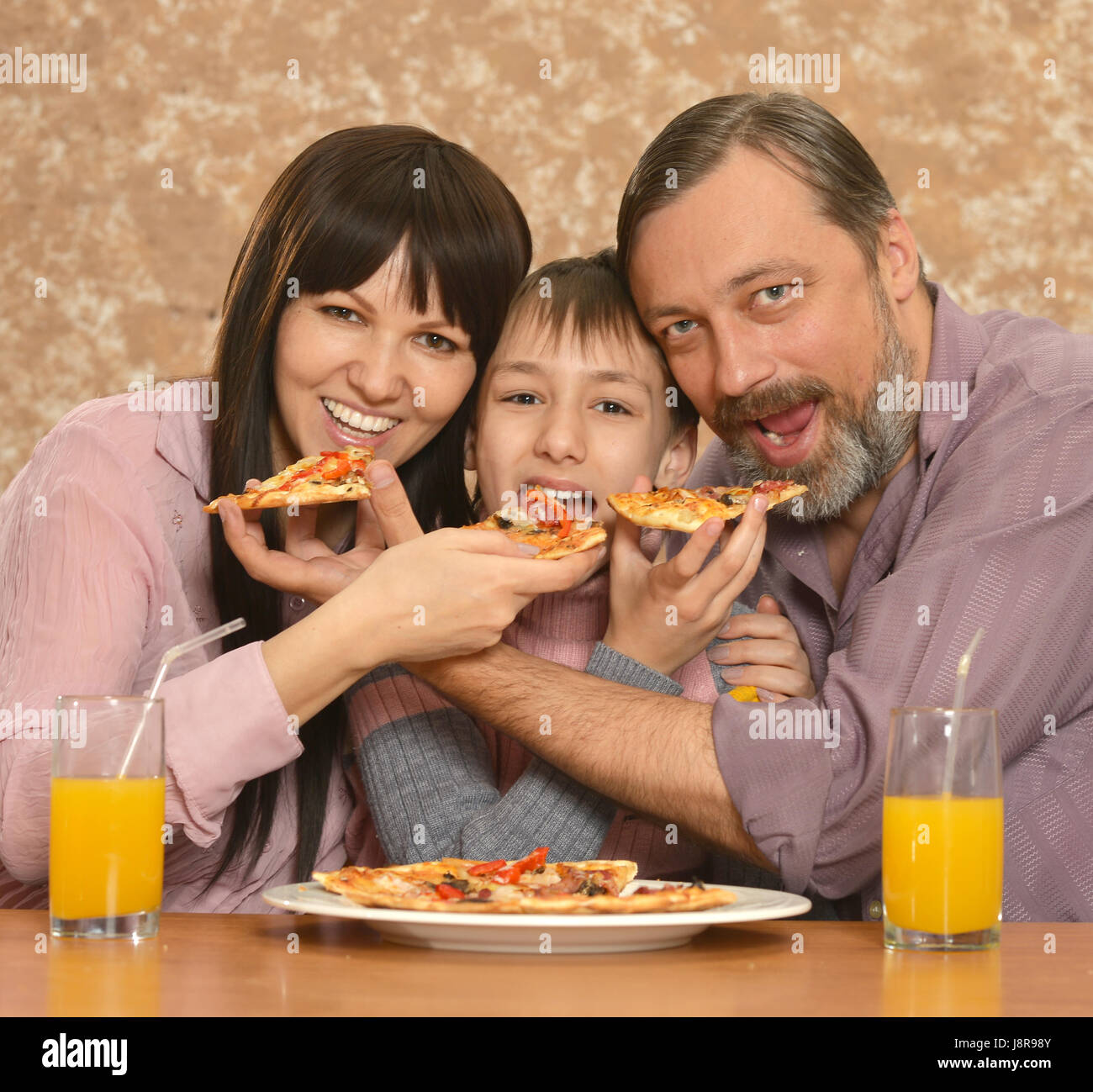 Eltern mit Sohn Pizza essen Stockfoto