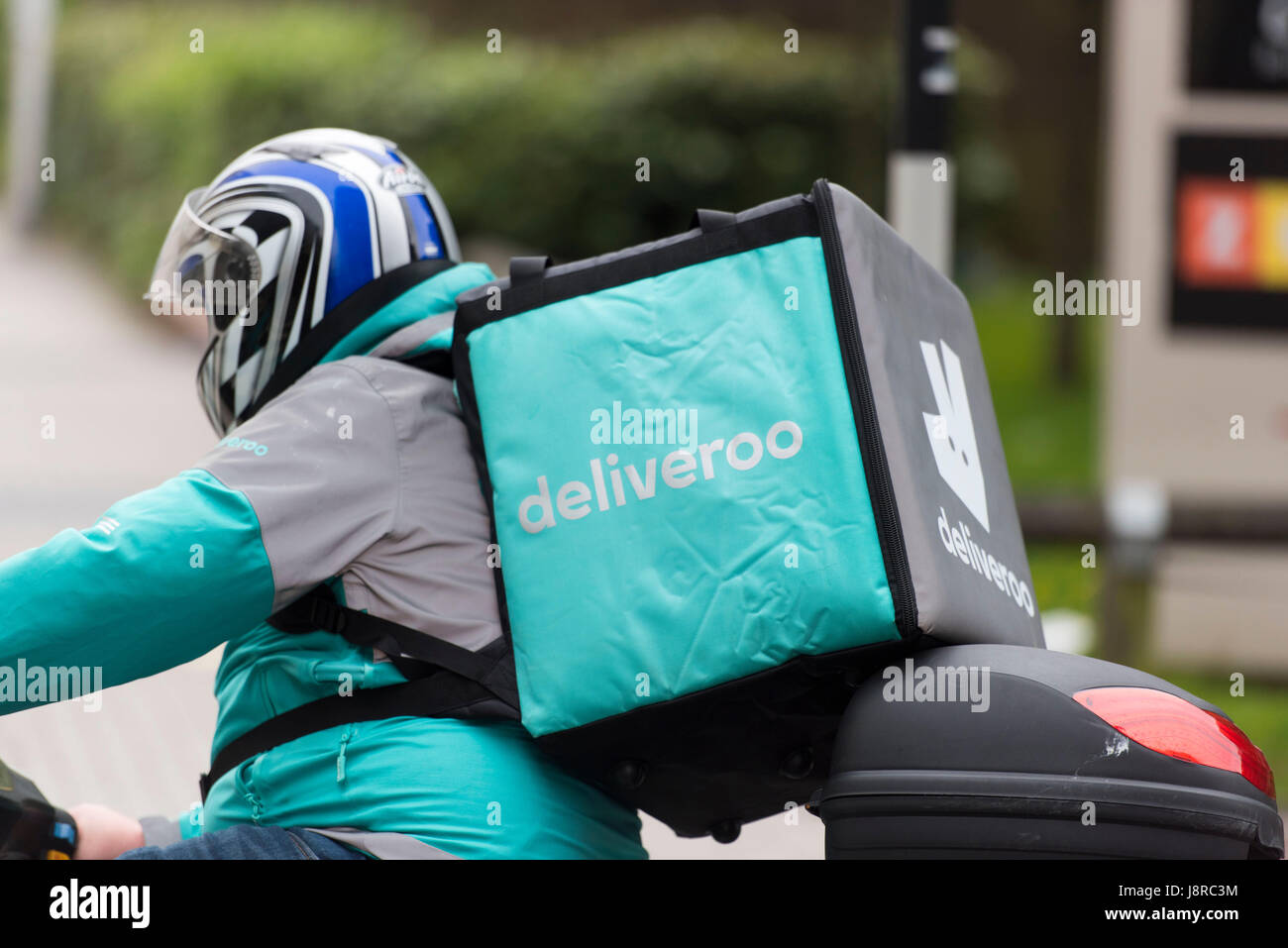 Ein Deliveroo Reiter auf einem Moped machen einen Lebensmittel-Lieferservice in Cardiff, Wales, UK. Stockfoto