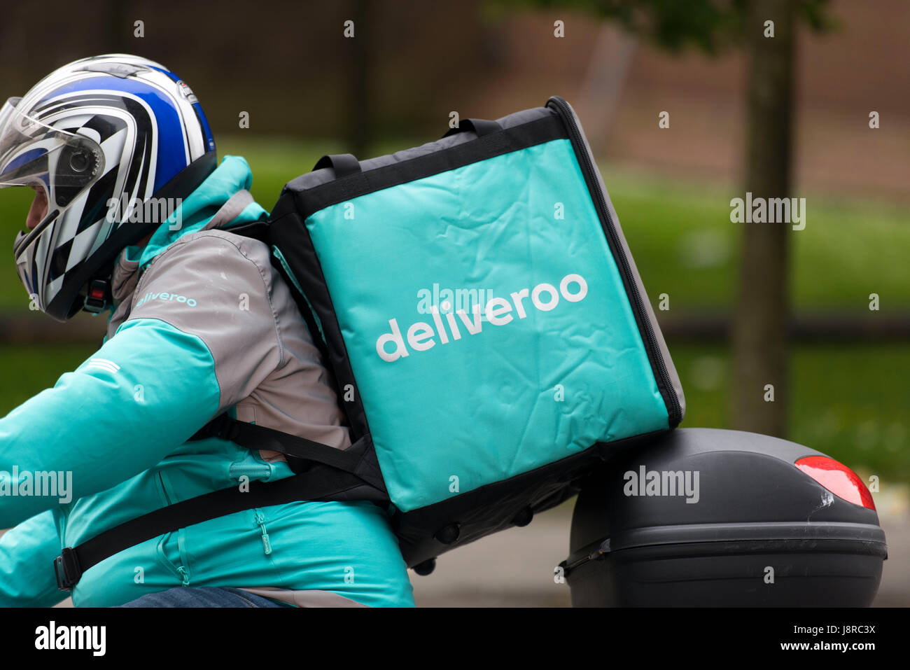 Ein Deliveroo Reiter auf einem Moped machen einen Lebensmittel-Lieferservice in Cardiff, Wales, UK. Stockfoto