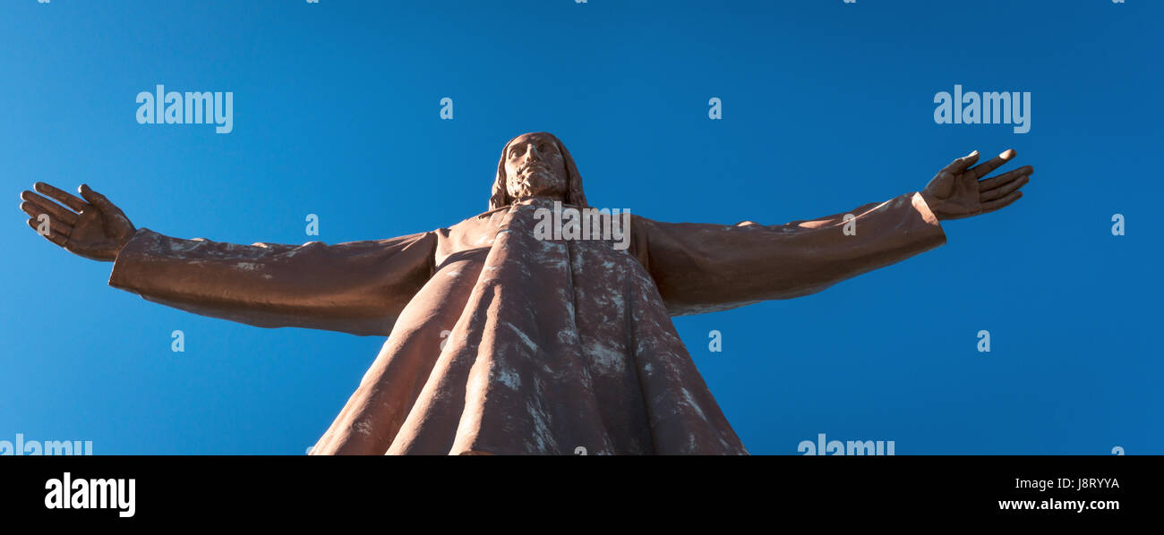 Christus-Statue mit offenen und einladenden Arme angezündet gegen blauen Himmel am Nachmittag. Stockfoto