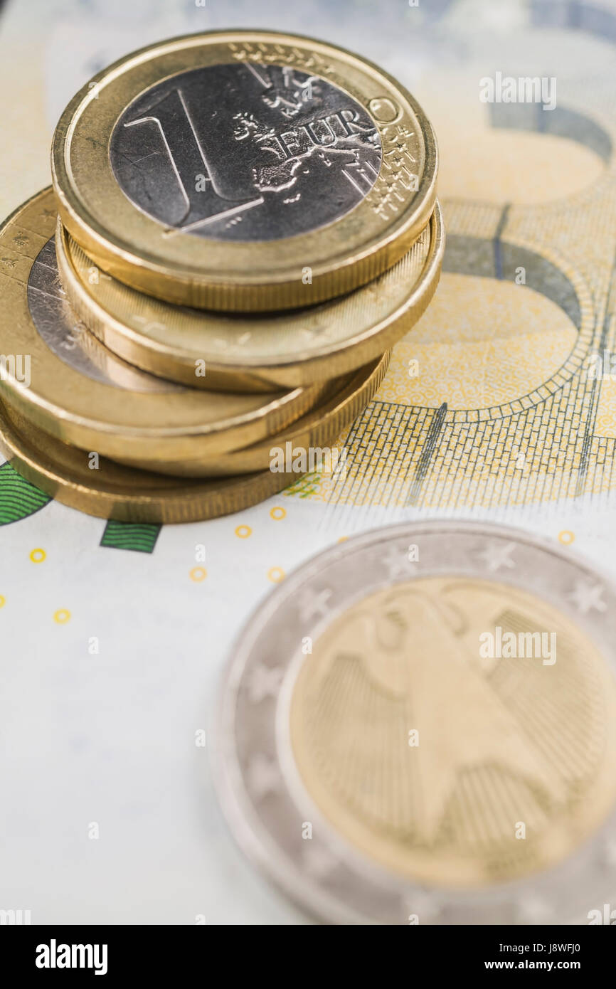 Stapel von Euro-Münzen auf fünf Euro-Papier-Währung-Banknote Stockfoto