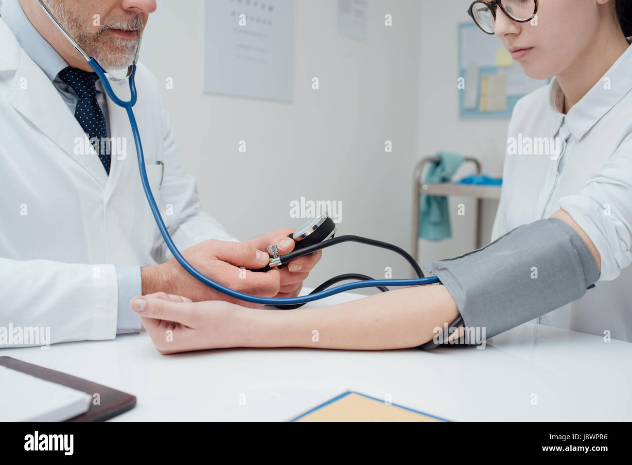 Arzt überprüft Blutdruck eines Patienten, misst er Herz Impulse mit einem Blutdruckmessgerät, Gesundheitswesen und Diagnostik-Konzept Stockfoto