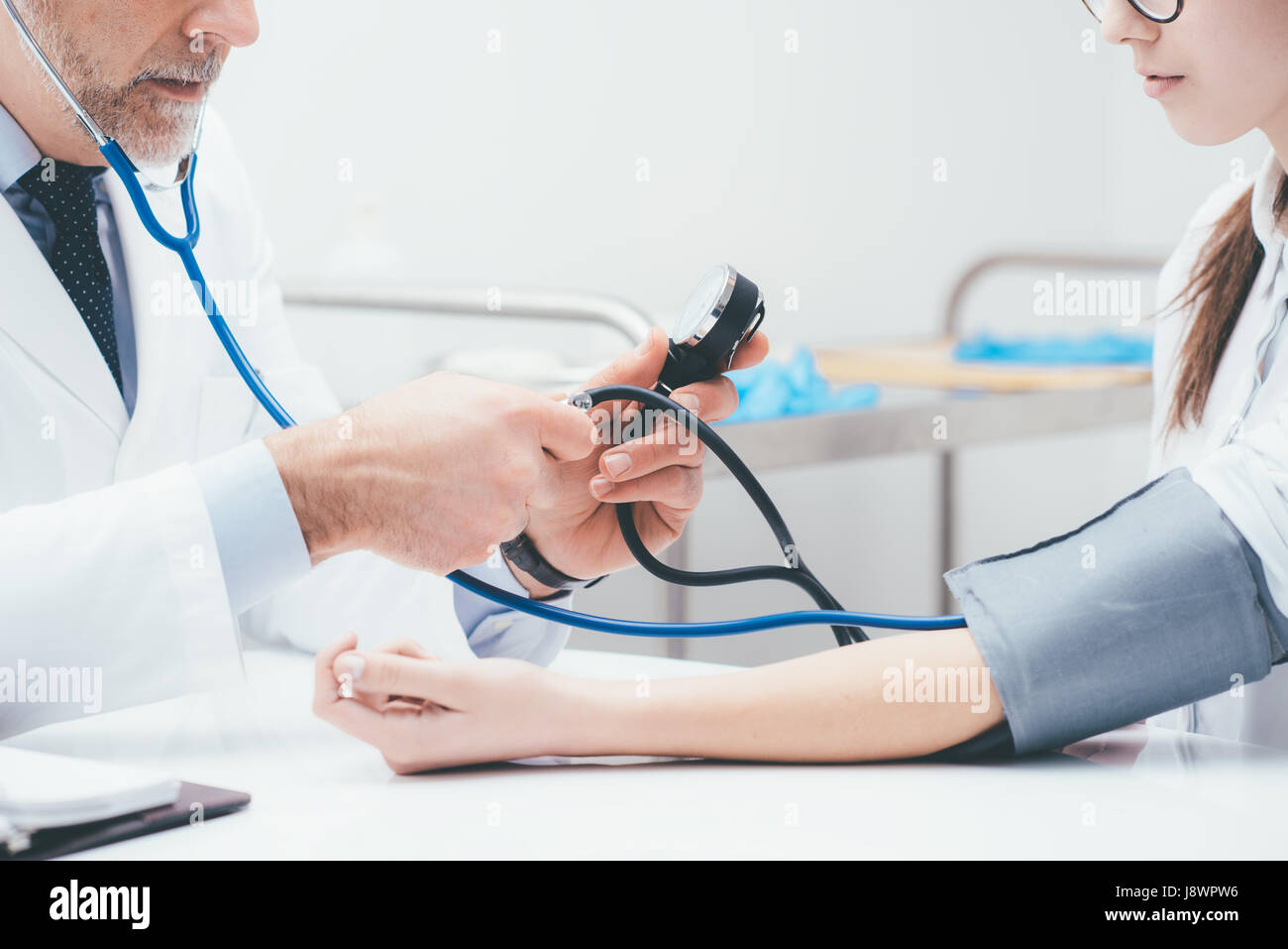 Arzt überprüft Blutdruck eines Patienten, misst er Impulse mit einem Blutdruckmessgerät, Nahaufnahme Stockfoto