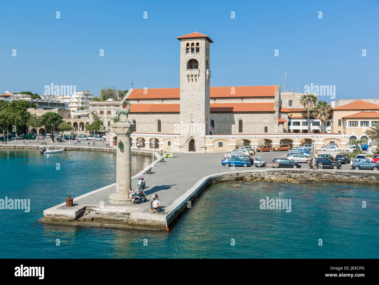 Rhodos, Griechenland - 12. Juni 2015: Blick auf eine Mandaki Hafen Port und Kapelle. Menschen zu Fuß auf einem Damm beobachten Rehe, Statuen und Fort St. Nikolaus Stockfoto