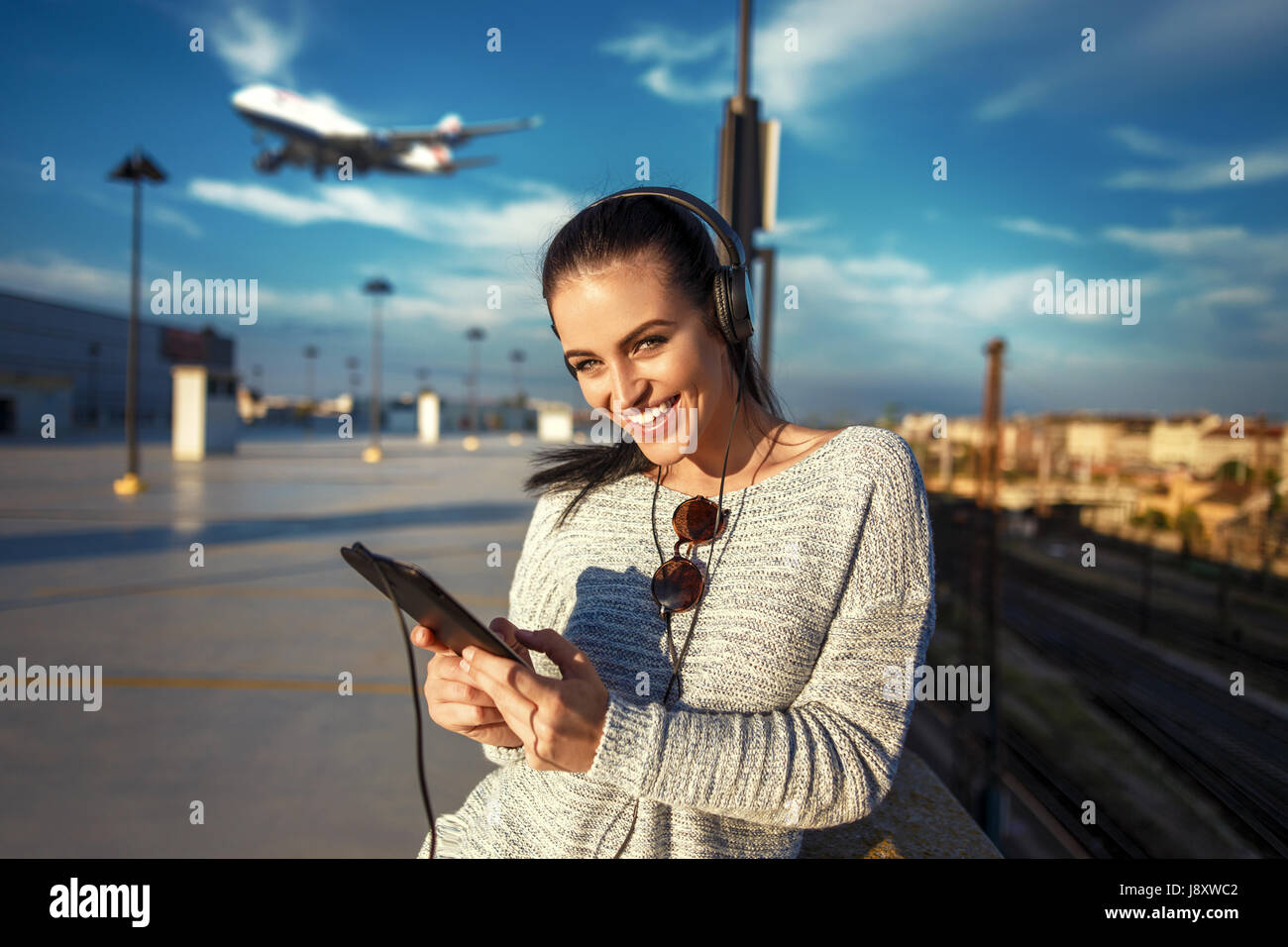 Junge Frau, die Bestellung von Flugtickets per Tablet am Flughafen Stockfoto
