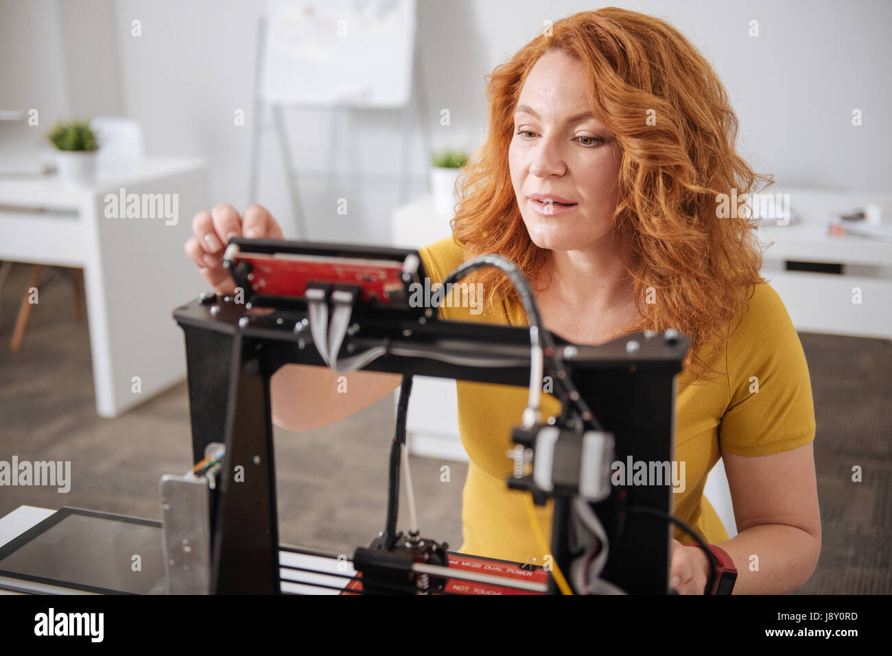 Ernst konzentrierte Frau 3d Drucker einrichten Stockfoto