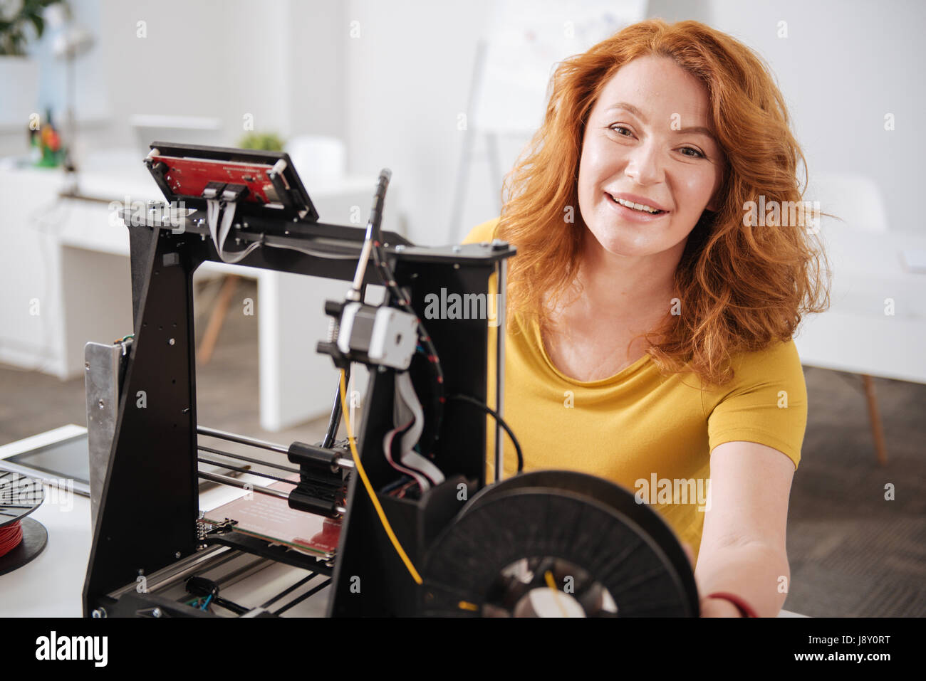 Positive fröhliche Frau, die Arbeit mit 3d Drucktechnologien Stockfoto
